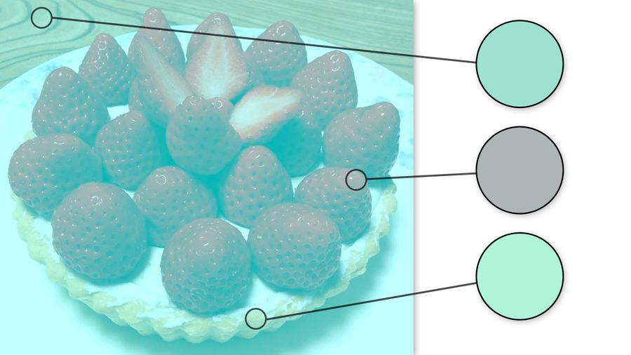 A cream pie covered in ripe strawberries sits on a large white plate on a wooden surface. The whole image is tinted with a bluish green filter. On top of the image, three black lines connect small circled areas on the image to larger circles on the right of the picture showing the color of the identified area. The top circle indicates that the seemingly tan wood is actually a light turquoise color. The middle circle shows that the seemingly bright red strawberries are really gray. The last cycle shows that the seemingly yellow crust of the pie is actually a mint color. Katie Miller